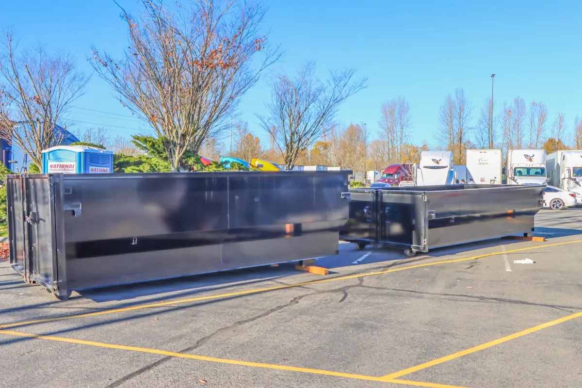 Professional dumpster rental service with roll-off container on residential driveway in East Palo Alto